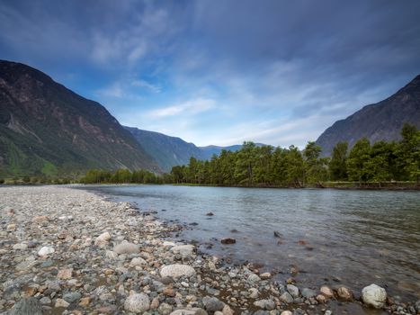 Early morning in the mountains, view from the river shore