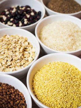 Cereals and grains in ceramic bowls standing on the table