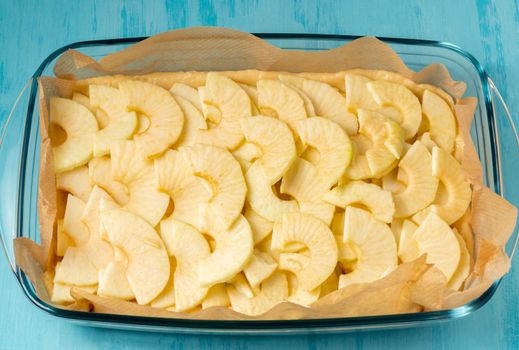 Unfolded apples on the dough in a baking dish. Cooking Apple Pie - photo, image.