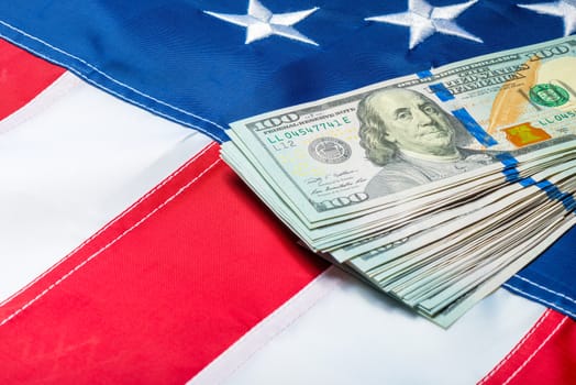 100 dollar bills lying on the stars of the American flag, close-up shot