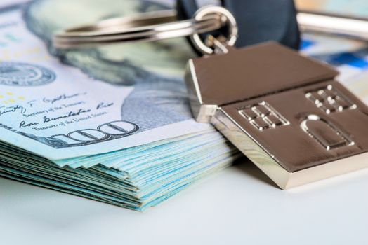 house key on a pile of american dollars on a white background close-up