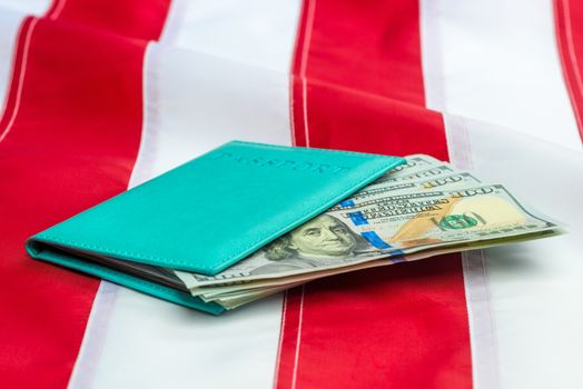 Passport stuffed with US dollars on a US flag close-up