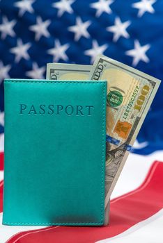100 dollar bills in a passport against the background of the American flag close-up