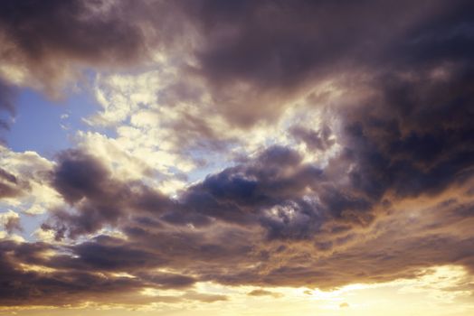 spectacular clouds in the sky at sunset, the blue sky is covered in clouds and it is orange and yellow on the horizon