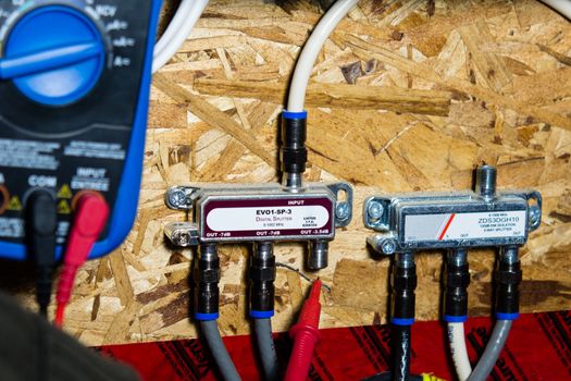 Electrician checks the connection of television cables on the panel