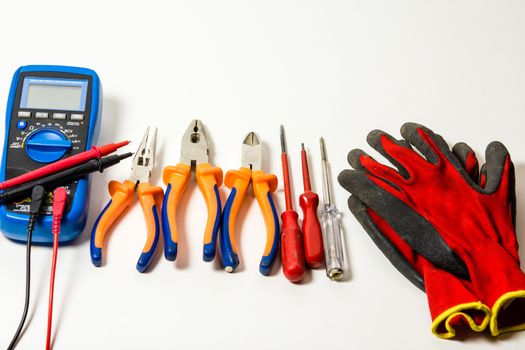 lectronic tester, gloves and screwdrivers isolated against white background