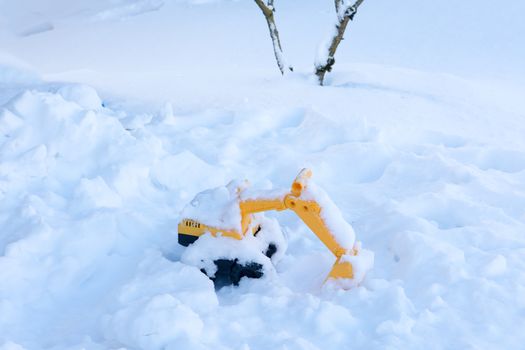 Children's toy left by young children in the snow near the house
