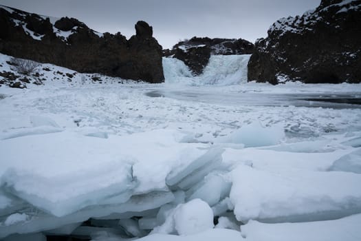 Frozen Hjalparfoss waterfall on a cloudy morning, winter in Iceland, Europe