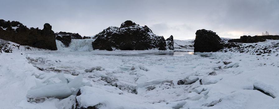 Frozen Hjalparfoss waterfall on a cloudy morning, winter in Iceland, Europe