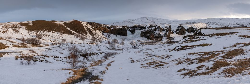 Frozen Hjalparfoss waterfall on a cloudy morning, winter in Iceland, Europe