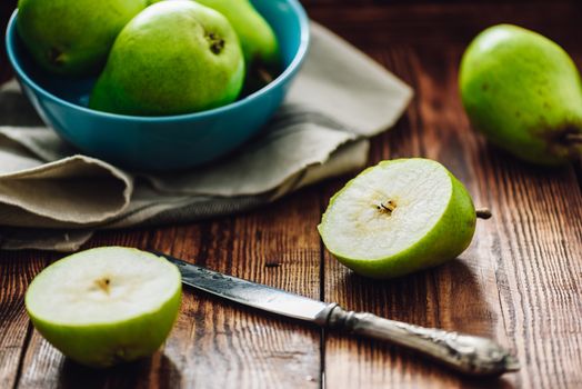 Sliced Pear with Knife and Some Pears on Background.