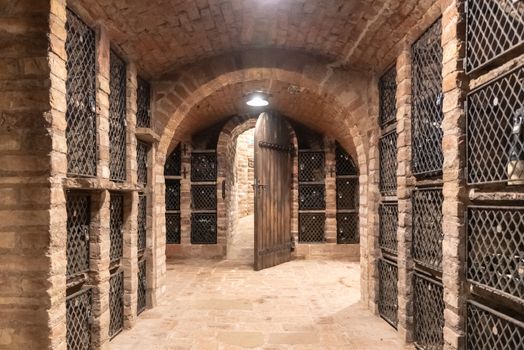 Old wine cellar with wine storage cases and open vintage wooden doors.