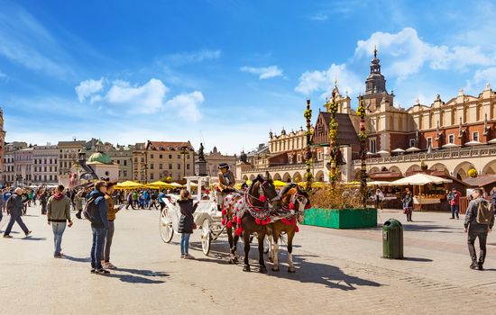 CHISINAU, MOLDOVA - APRIL 19, 2019: Horse drawn carriages with guides in front of the St. Mary's Basilica in Krakow, Poland. About a fifty carriages make tours around the center of Krakow.