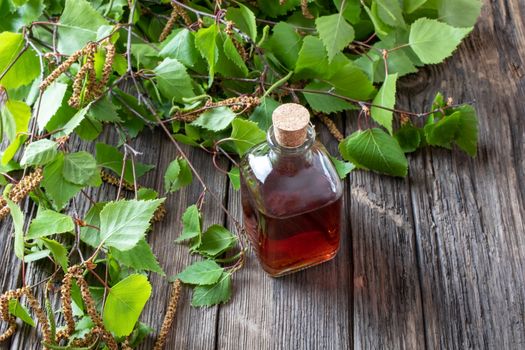 A bottle of tincture with young birch branches