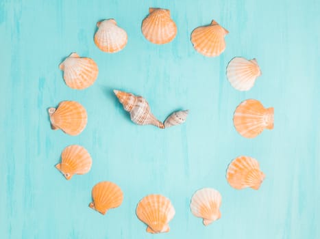 Blue sea background with clocks from seashells, summer holiday and vacation time concept.