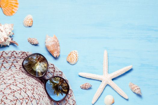 Blue sea background with hat, sunglasses and seashells, summer holiday and vacation time concept.