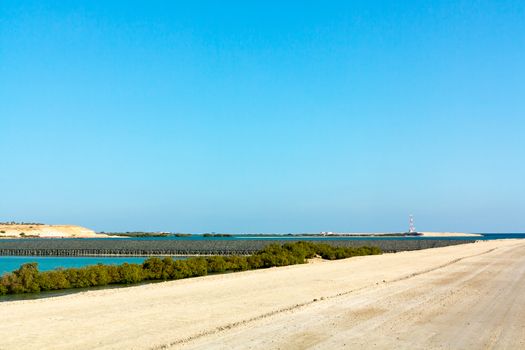 road along the sandy bulk dam in Abu Dhabi.