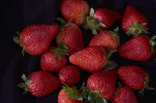 Strawberries on black background, long exposure natural light