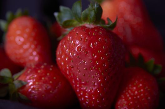 Strawberries on black background, long exposure natural light