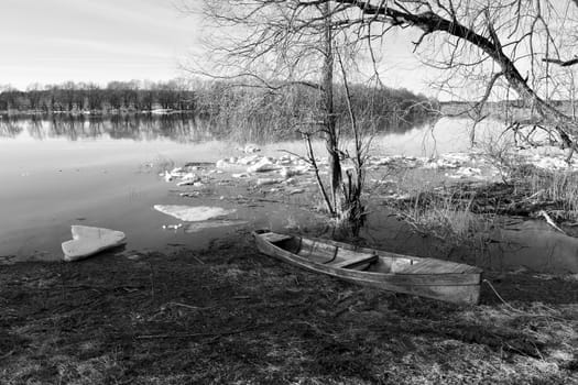 spring spill, boat on the river bank,black and white image