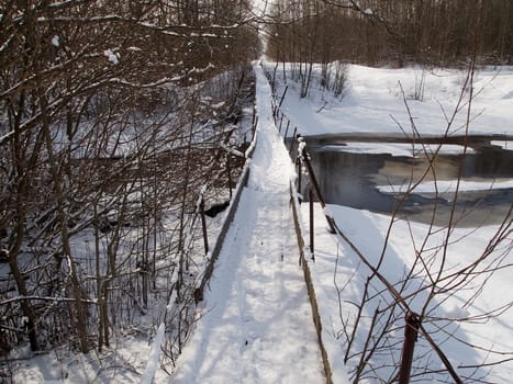 winter, a suspension bridge over a small river