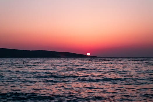 a wide landscape shoot of sea at sunset with good colors. while sun is going down.