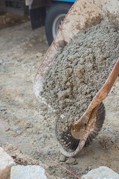 Construction site work with concrete mixer and wheelbarrows