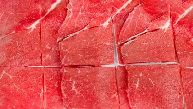 Top view of some raw beef on a plate over white background