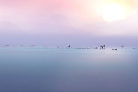 The calm sea reflects the clear sky like a mirror with pastel color