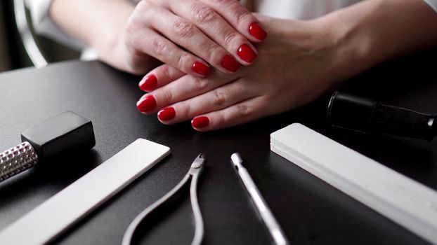 Nail Care. Perfect Nails Painted With Red Nail Polish On Black Background. Professional Manicure Tools. Beauty Car