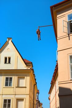 PRAGUE, CZECH REPUBLIC - July, 2018: Sculpture of the psychoanalyst Sigmund Freud hanging by a hand called Man Hanging Out created by the artist David Cerny