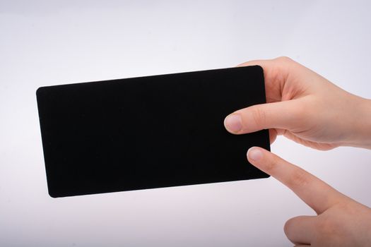 Rectangular shaped black notice board in hand on white background