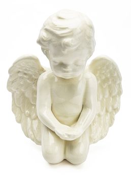 small figurine of white angel, kneeling with open wing