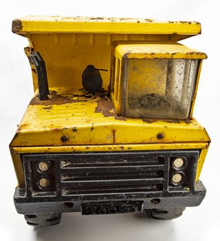 Rusted yellow toy truck isolated against white background