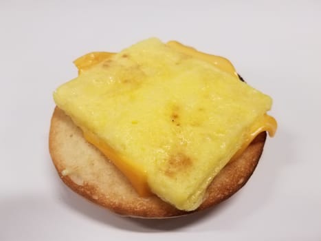sandwich on white desk with bun, egg, and cheese