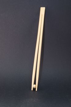Chopsticks with tablets against a black background. Concept of health costs and drug misuse.