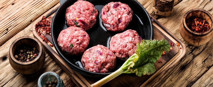 Meat balls from raw beef force-meat in iron cast pan