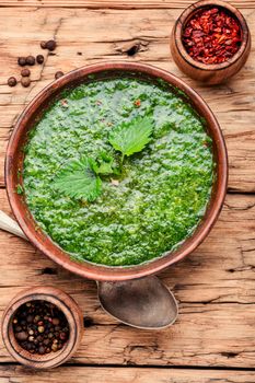 Nettle cream soup on wooden background.Soup with fresh nettles