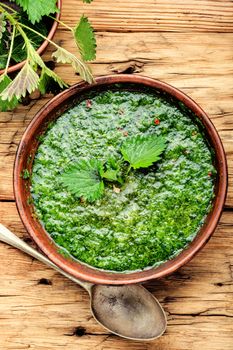 Nettle cream soup on wooden background.Soup with fresh nettles