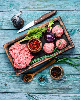 Fresh minced beef on cutting board and ingredients.Raw mixed minced meat meatballs