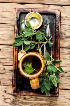 Green melissa herbal tea in cup.Healing medical herbs