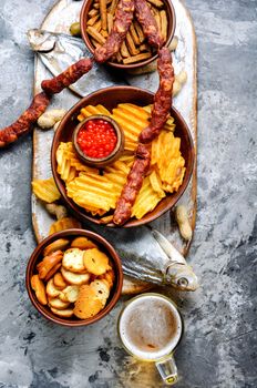 Selection of beer and snacks.Chips, fish, beer sausages on the table