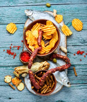 Selection of beer and snacks.Chips, fish, beer sausages on the table