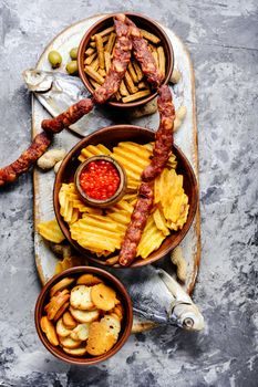 Selection of beer and snacks.Chips, fish, beer sausages on the table