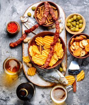 Selection of beer and snacks.Chips, fish, beer sausages on the table