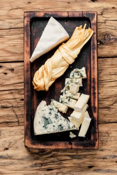 Various types of cheese on rustic wooden table