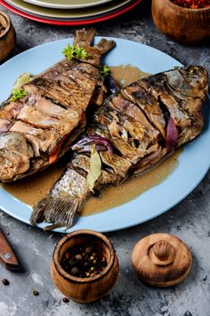 Grilled fish with lemon on rustic dark wooden background