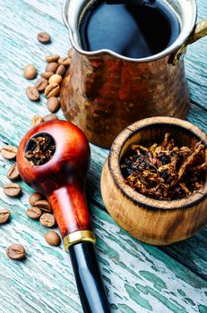 Stylish tobacco pipe with tobacco and brewed coffee