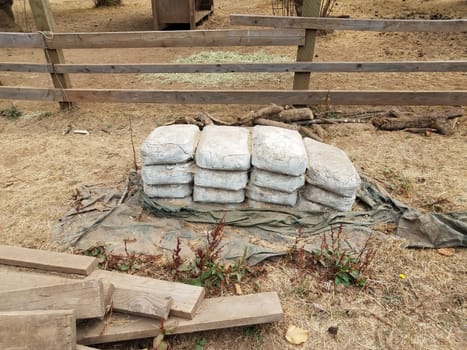 wooden fence and stacks of old bags of cement on farm