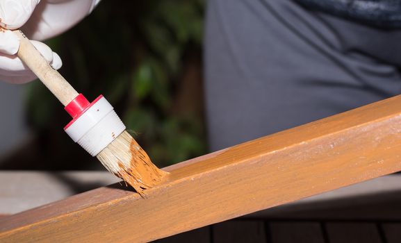 Woman strokes a wooden table with fresh paint